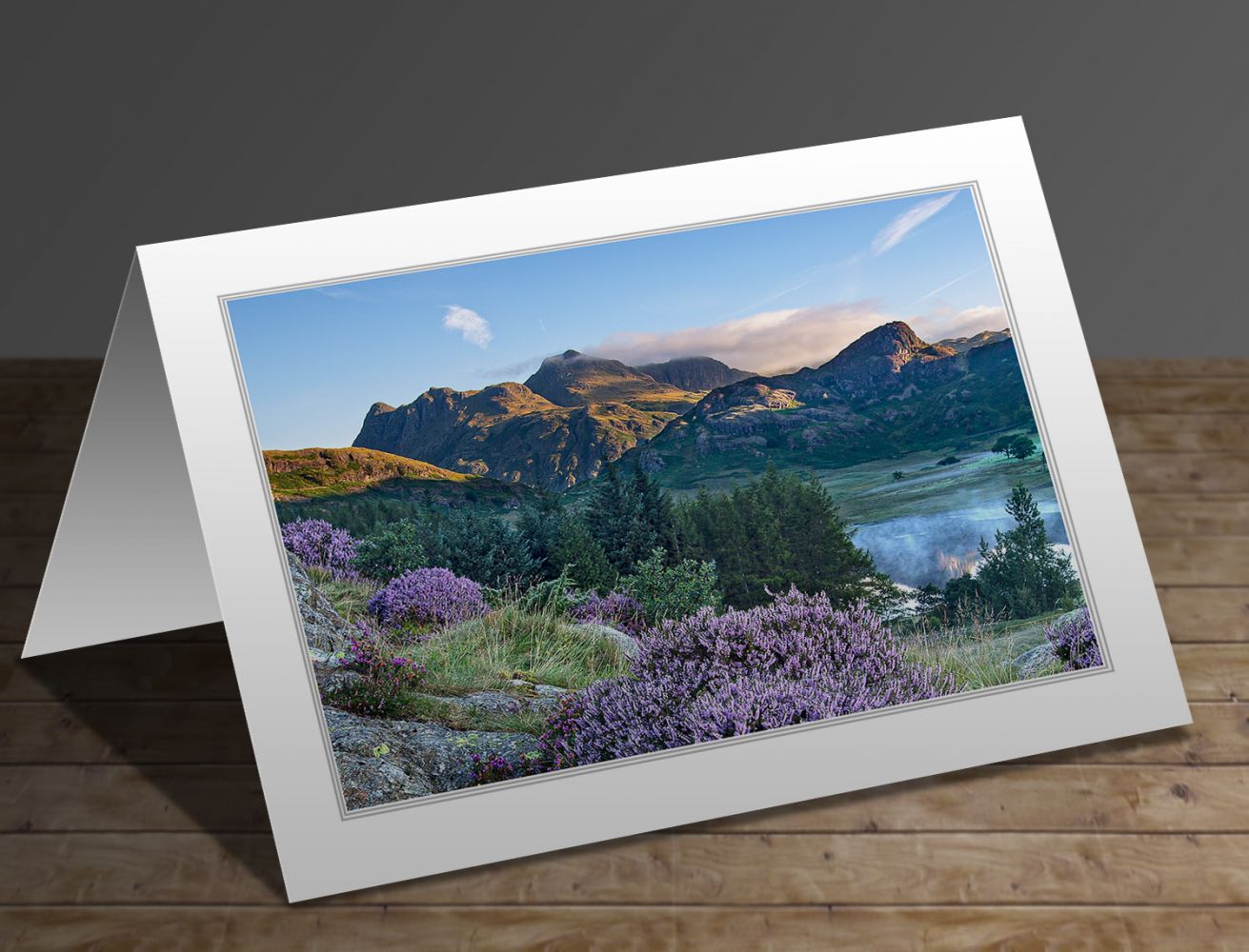 A greetings card containing the image Heather surrounds a misty Blea Tarn and the Langdales