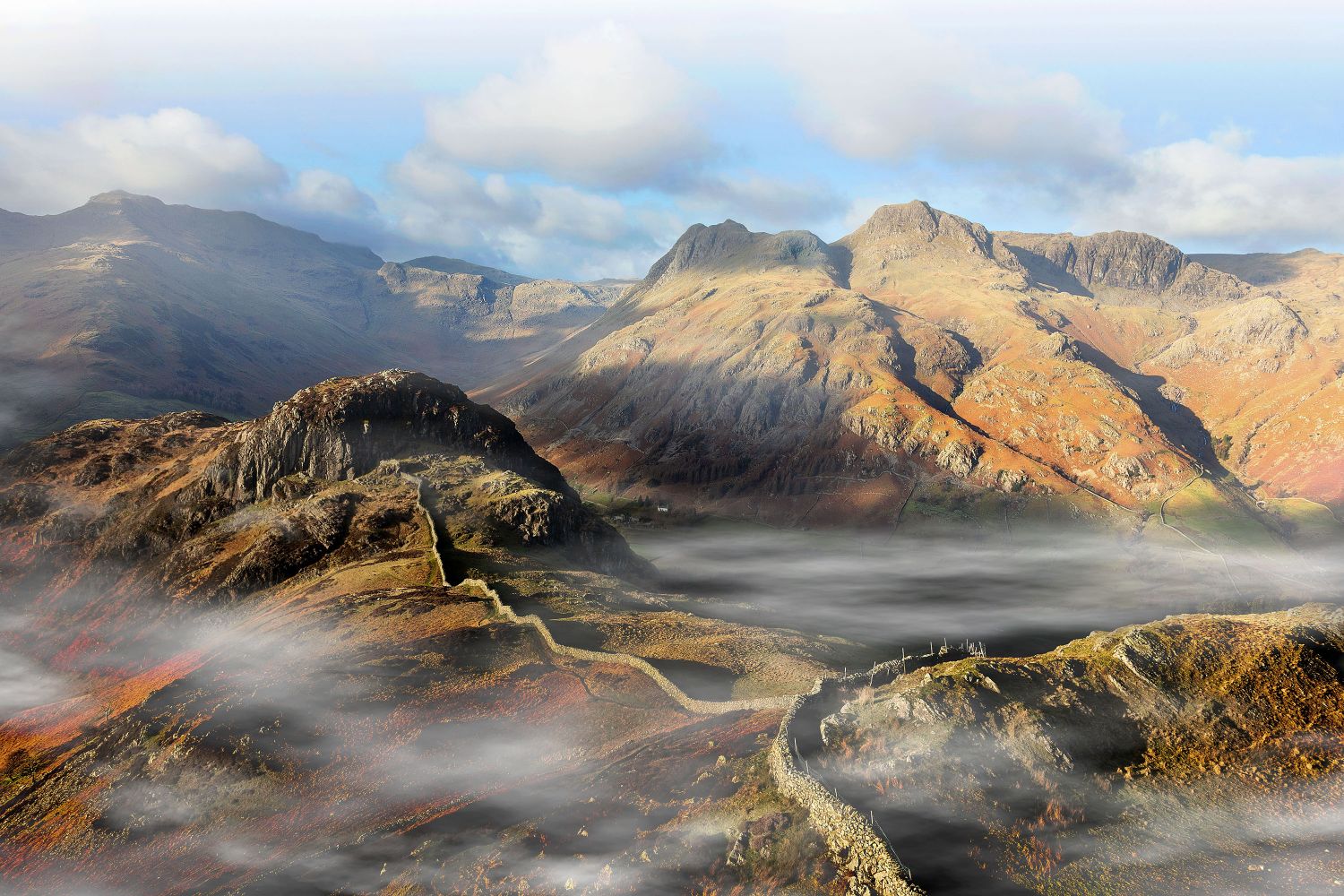 Early morning mists surrounds the Langdale Pikes by Martin Lawrence