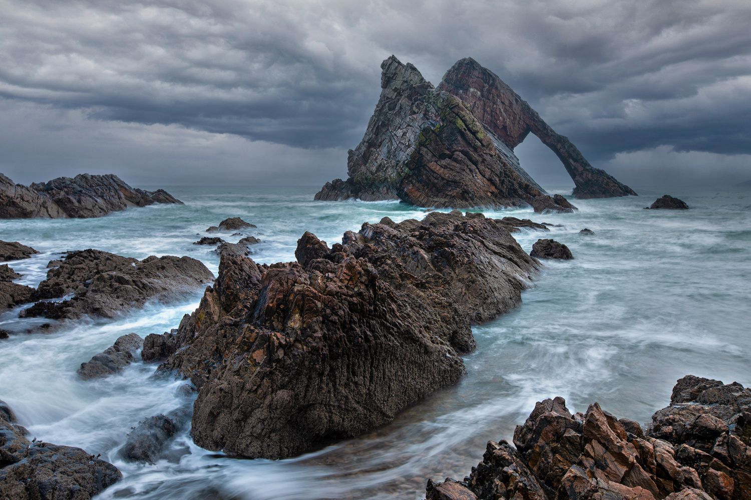 Storm clouds roll in at Bow Fiddle Rock near Aberdeen by Martin Lawrence Photography