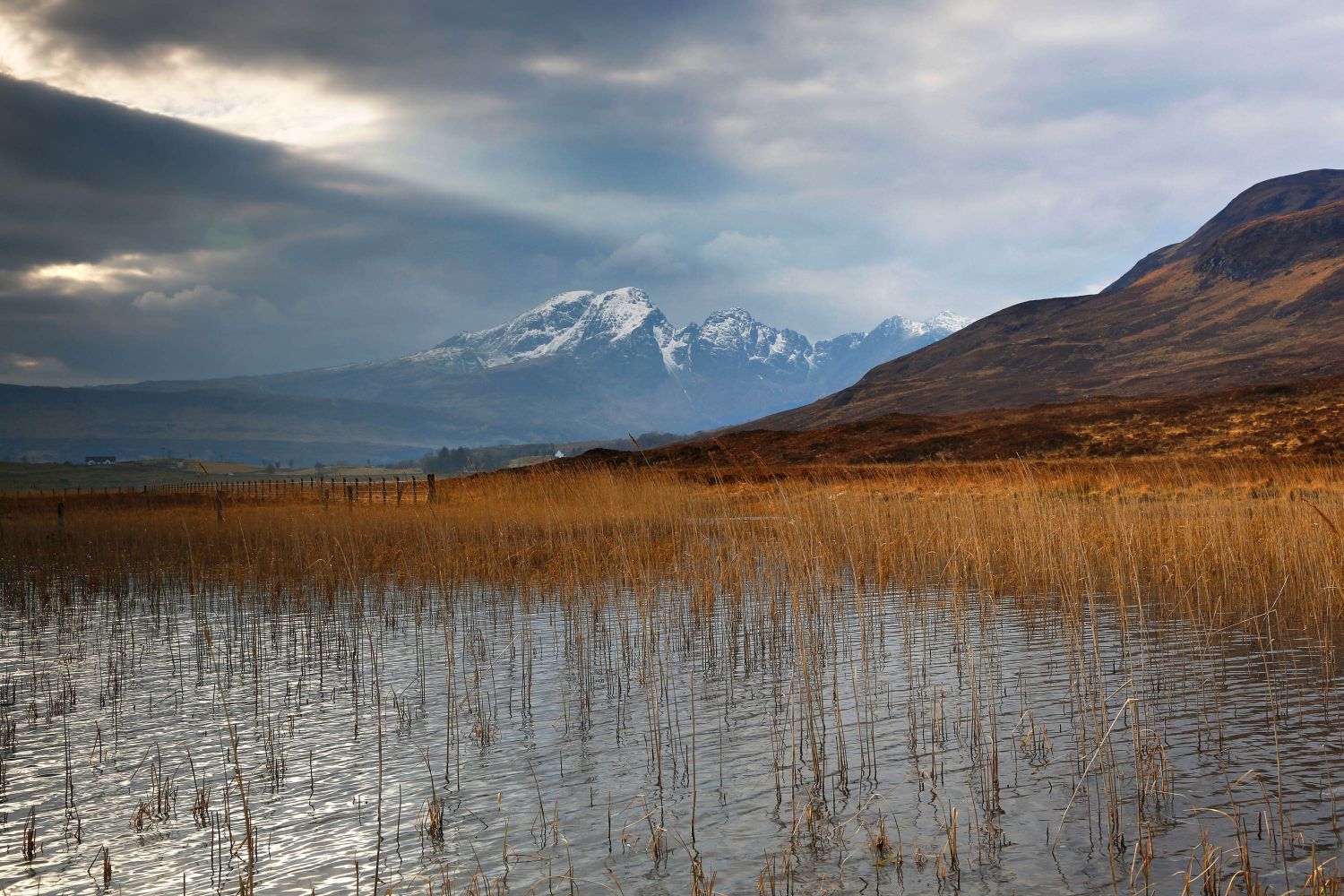 Sun rays breaking up a stormy sky over Blaven taken from the road to Elgol