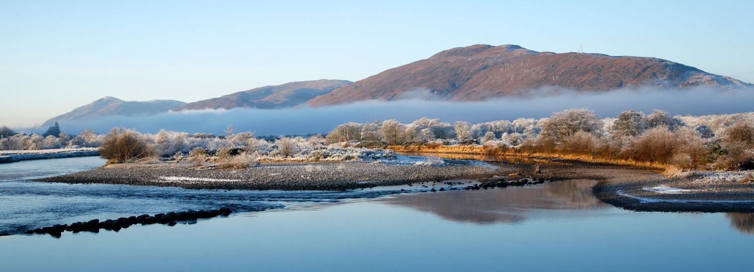 River Lochy from Inverlochy Castle with low lying mist over frost covered trees