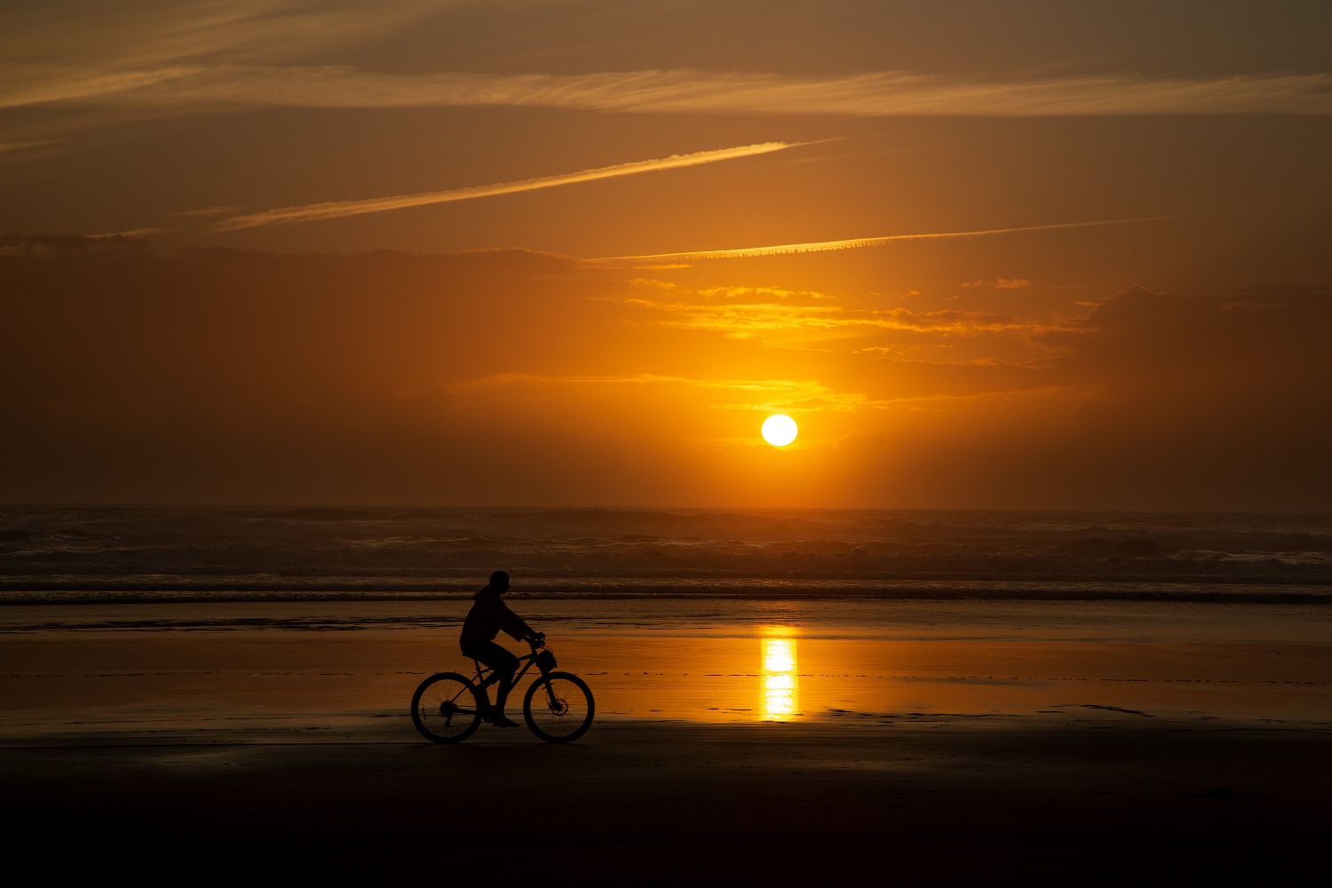 Cyclist silhouette on Cannon Beach Oregon